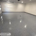 Finished medium broadcast flake garage floor in Medium Gray polyaspartic, high gloss and reflective under garage lighting