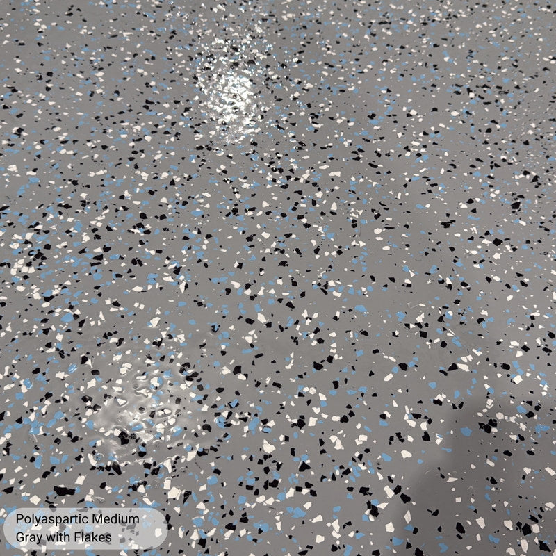 Close-up of medium broadcast polyaspartic flake in Medium Gray showing black, white and blue flecks sealed under a clear topcoat