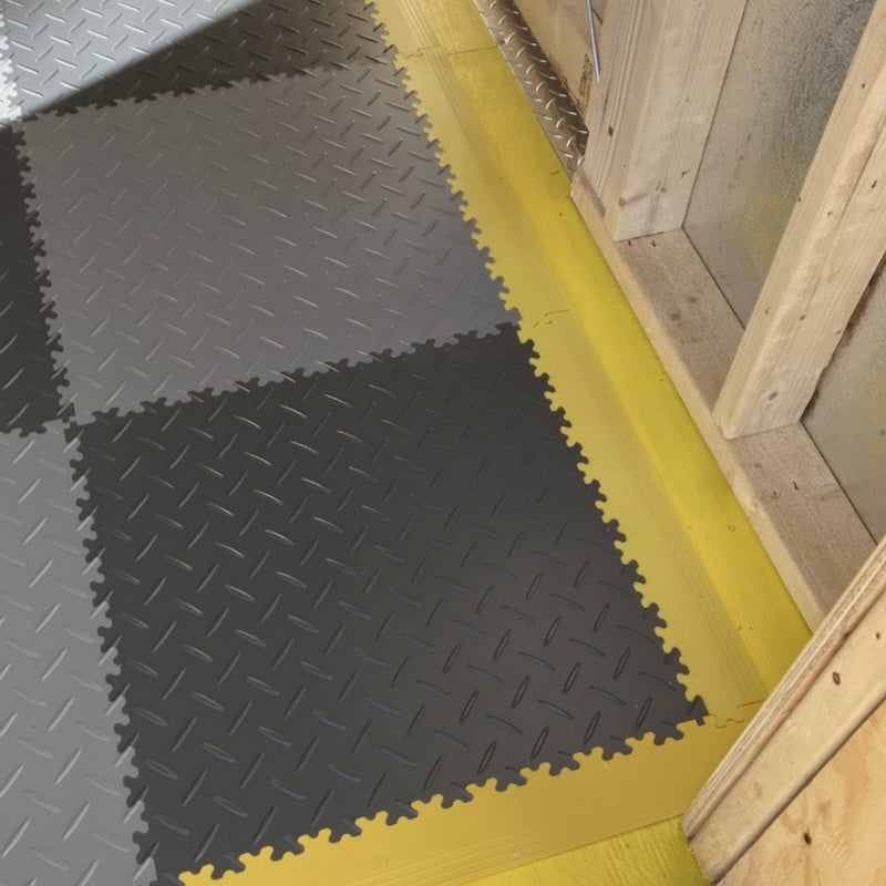 Black And Gray Diamond Plate PVC Garage Tiles With Yellow Edging Close Up