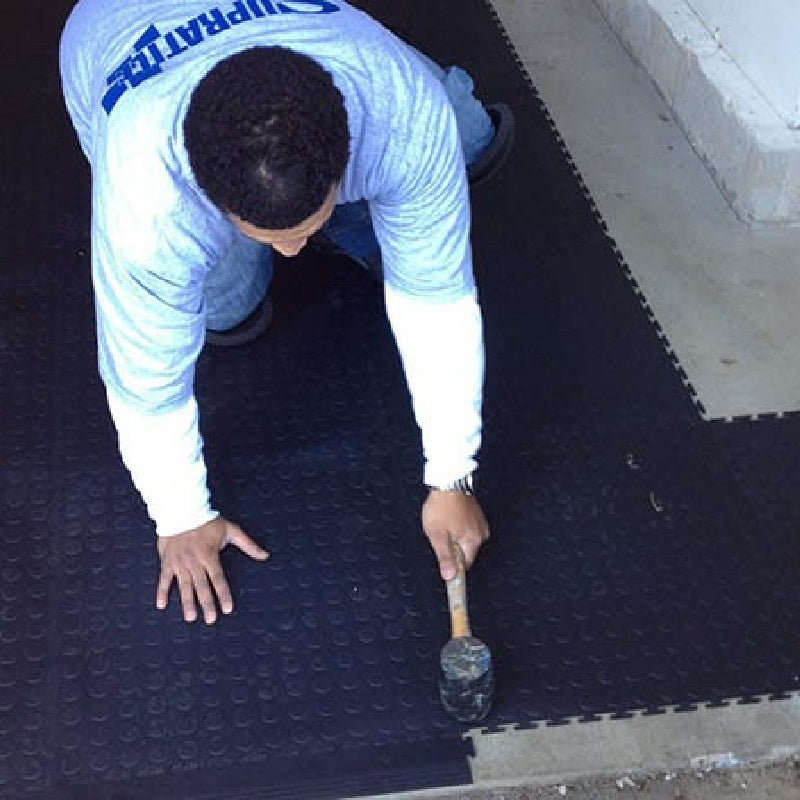 Installer Showing Ease As He Adds The Black PVC Edging To The Black SupraTile Coin Floor