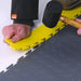 Lightly Tapping The SupraTile PVC Edge Piece Into The T-Joint Pattern Of The SupraTile Coin Floor