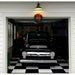 Classic Black Truck in Garage with Festive Wreath on Black and White Checkered RaceDeck Tile XL Floor and Vintage Automotive Memorabilia