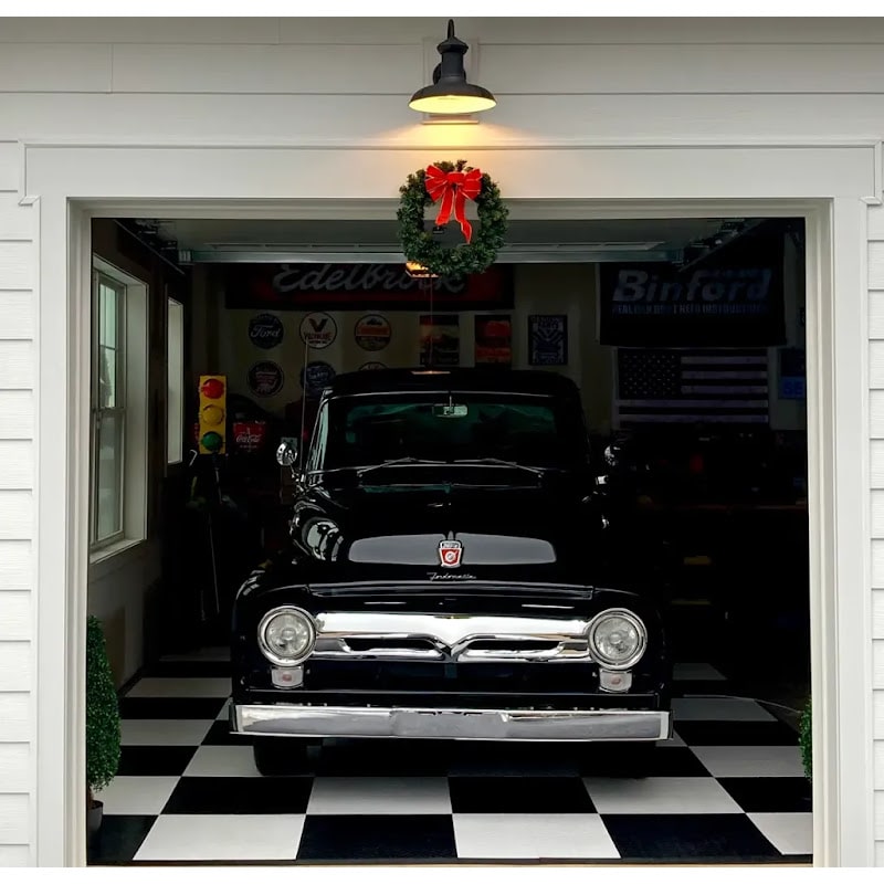 Classic Black Truck in Garage with Festive Wreath on Black and White Checkered RaceDeck Tile XL Floor and Vintage Automotive Memorabilia