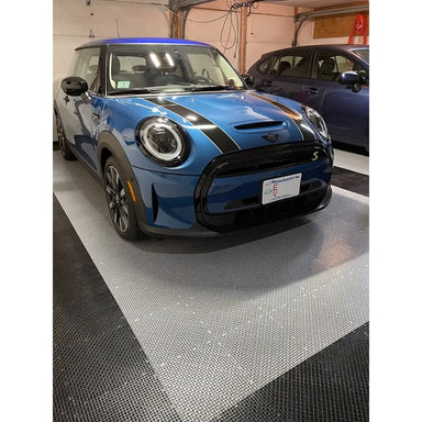 Garage interior featuring RaceDeck Garage Flooring, showcasing a blue Mini Cooper on a sleek black and gray tile pattern