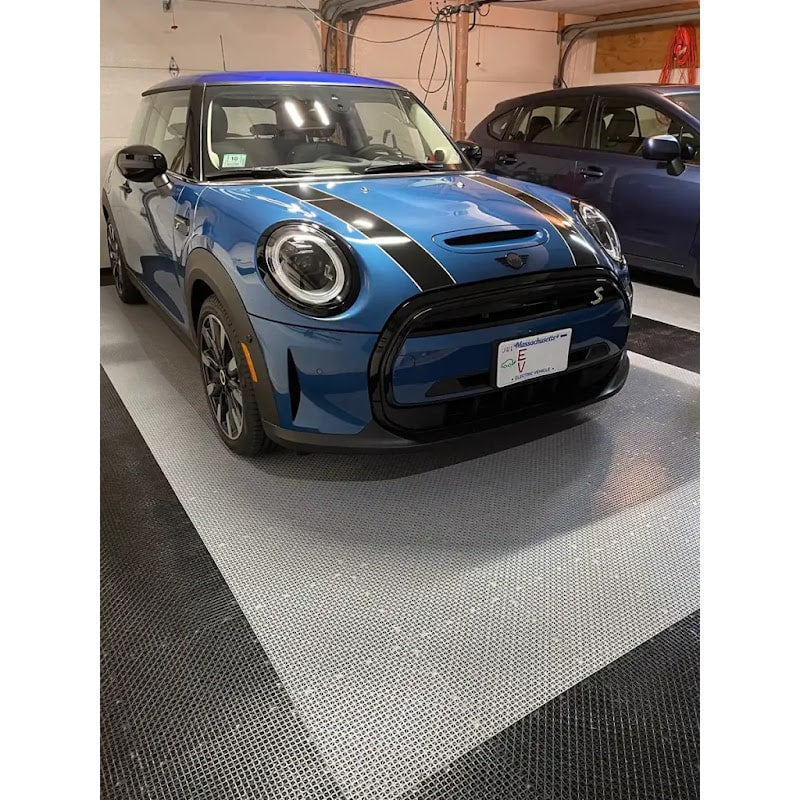 Garage interior featuring RaceDeck Garage Flooring, showcasing a blue Mini Cooper on a sleek black and gray tile pattern