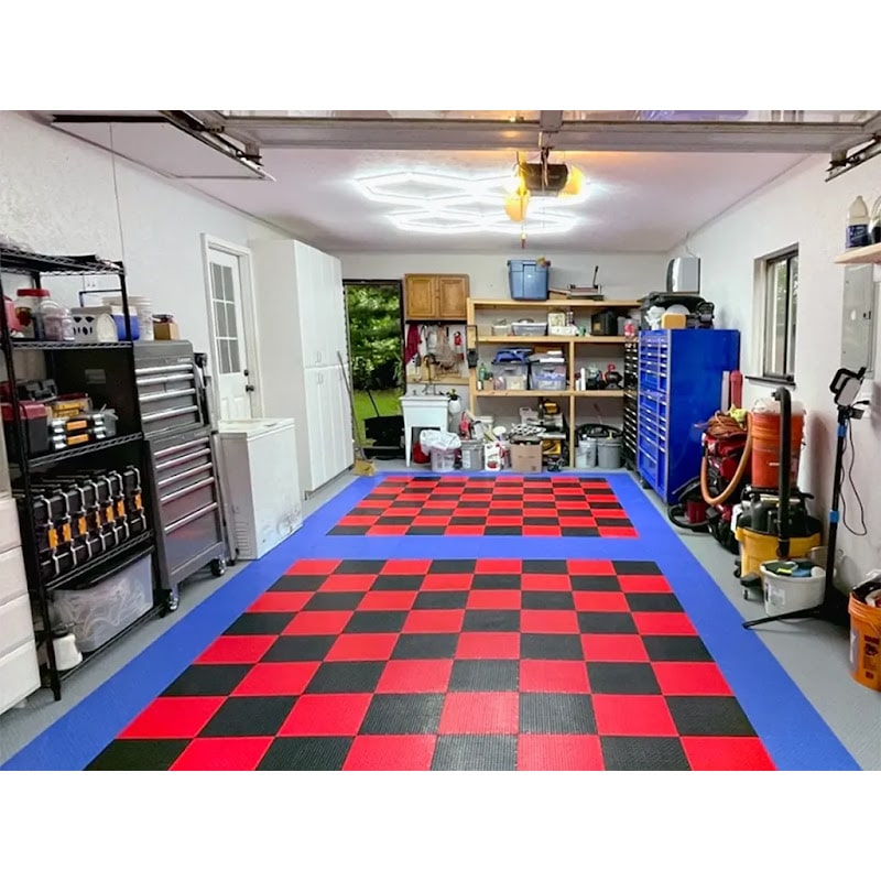 Well-organized garage with Race Deck Tiles, featuring a bold red and black checkered floor design and various tools and supplies