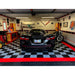 Sleek black Corvette and motorcycle resting on RaceDeck Circle Trac Garage Flooring System in alloy and black with a striking red border