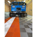 Garage featuring RaceDeck Free-Flow XLC Flooring Tiles, showcasing a blue tracked vehicle on a striking orange and gray patterned floor