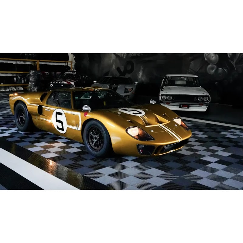 Garage scene with RaceDeck Free-Flow XLC tiles, showcasing a classic gold Ford GT40 on a stylish black and white checkered floor