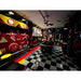 Themed garage with RaceDeck TuffShield tiles, featuring a stylish entertainment area adorned with vintage signs and a bold checkered floor