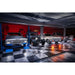 Classic car garage featuring RaceDeck TuffShield Diamond Flooring Tiles, with vintage cars illuminated under dramatic lighting on a checkered floor