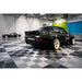 Stylish garage interior showcasing RaceDeck Tiles XLC, featuring a black Hoonigan car on a sleek gray and black checkered floor