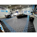 Modern garage with RaceDeck Tiles XLC, featuring a black sports car and a truck on a stylish blue and black checkered floor