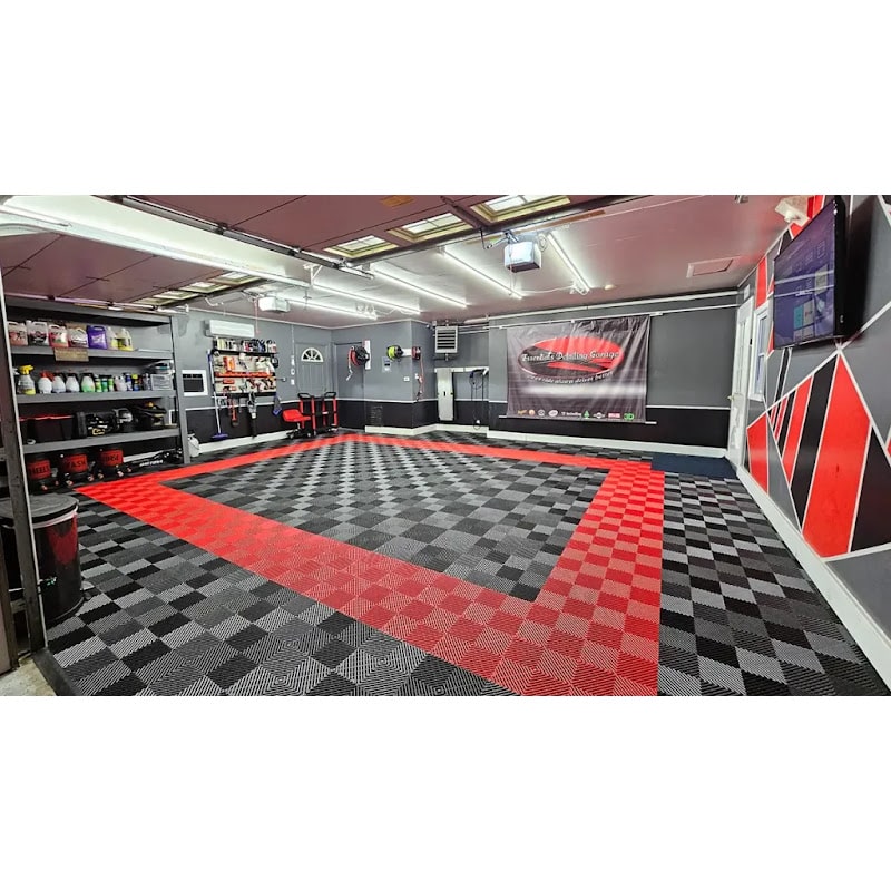 Well-organized garage featuring XLC Race Track Flooring, showcasing a spacious area with a bold red and black checkered design