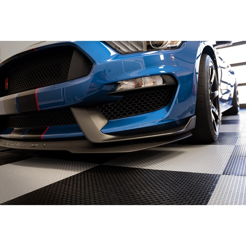 Close-up of a blue Shelby Mustang on Racedeck Garage Floor Tiles, highlighting the car's aggressive front design against a checkered floor