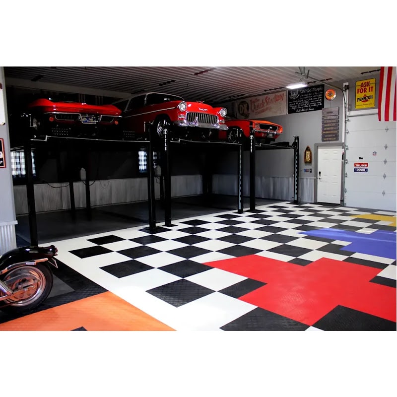 Spacious Garage with Black and White Checkered RaceDeck Tile XL, Three Classic Cars on Lifts, and a Vintage Motorcycle Parked Below